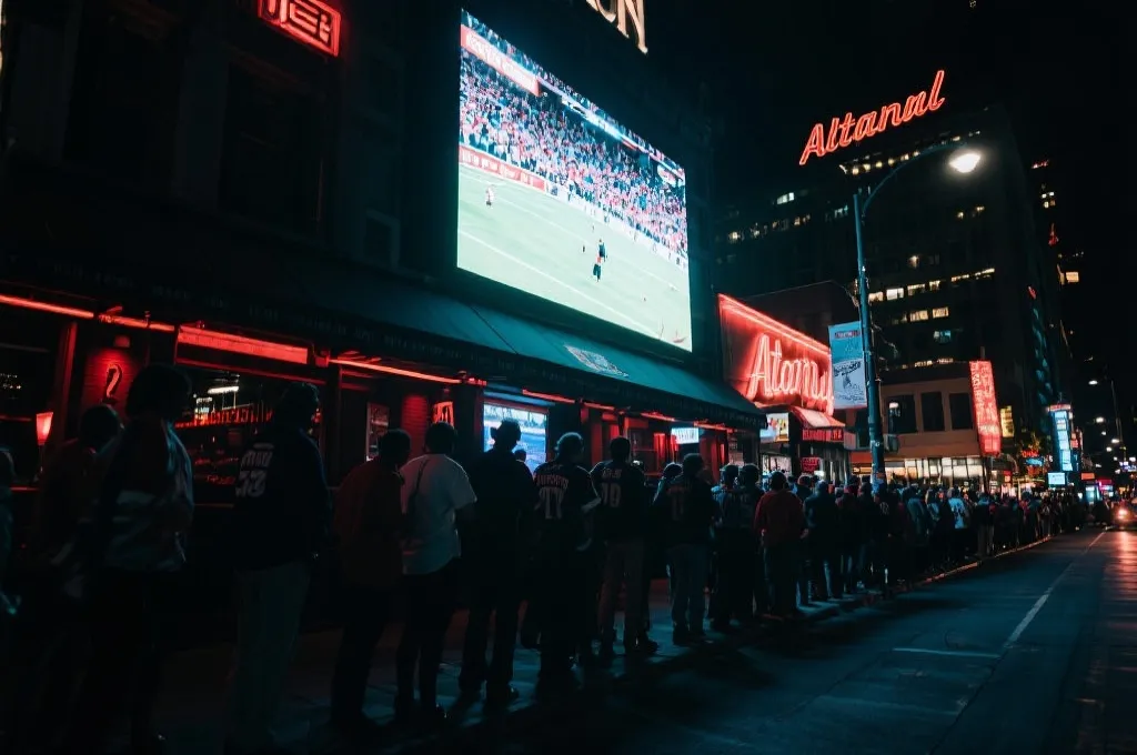 亚特兰大夜晚公共观赛区或酒吧外的霓虹与球迷剪影